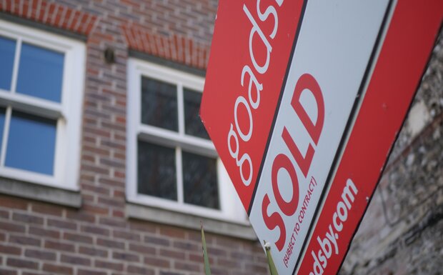 An abstract view of a 'sold' sales board is pictured outside a flat.